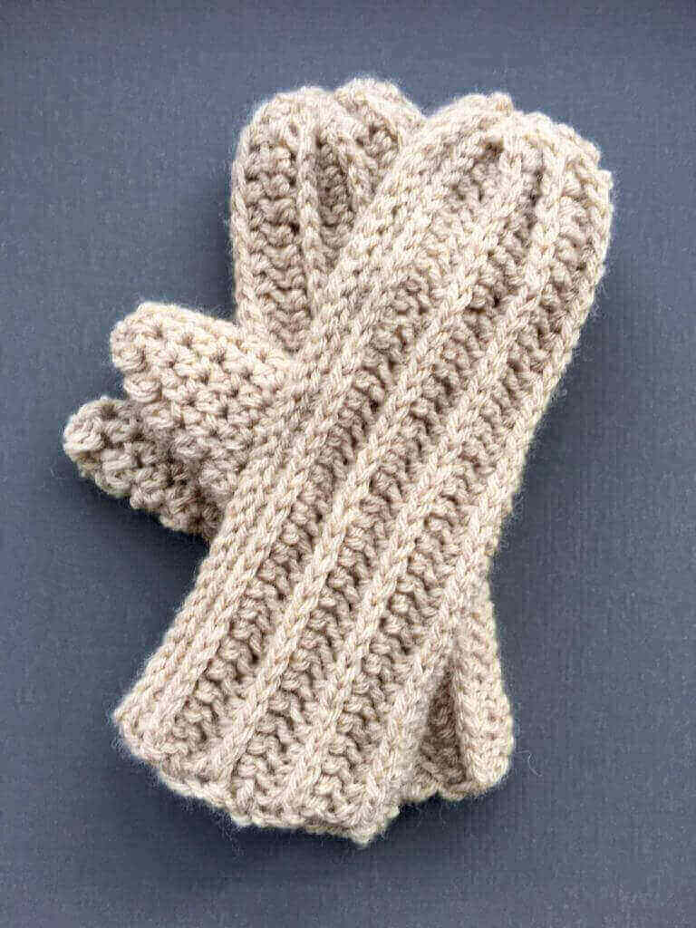 A pair of chunky crochet mittens made in half double crochet stitches, using wool blend yarn.